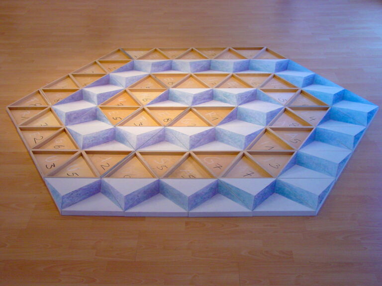 Hexagonale Bodeninstallation aus geometrischen Modulen mit spiralförmiger Anordnung, die an Wasserbewegungen und kristalline Strukturen erinnert.