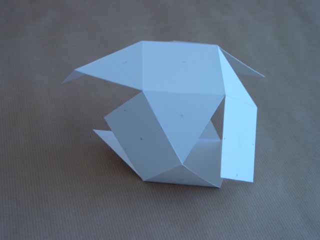 Hexagonale Flächen und Räume“ aus der Serie Labyrinthe, Irrgärten und andere Behausungen. Weißes, gefaltetes Papierobjekt aus ineinandergreifenden geometrischen Flächen, die einen unregelmäßigen, räumlichen Körper mit Öffnungen und Hohlräumen bilden.